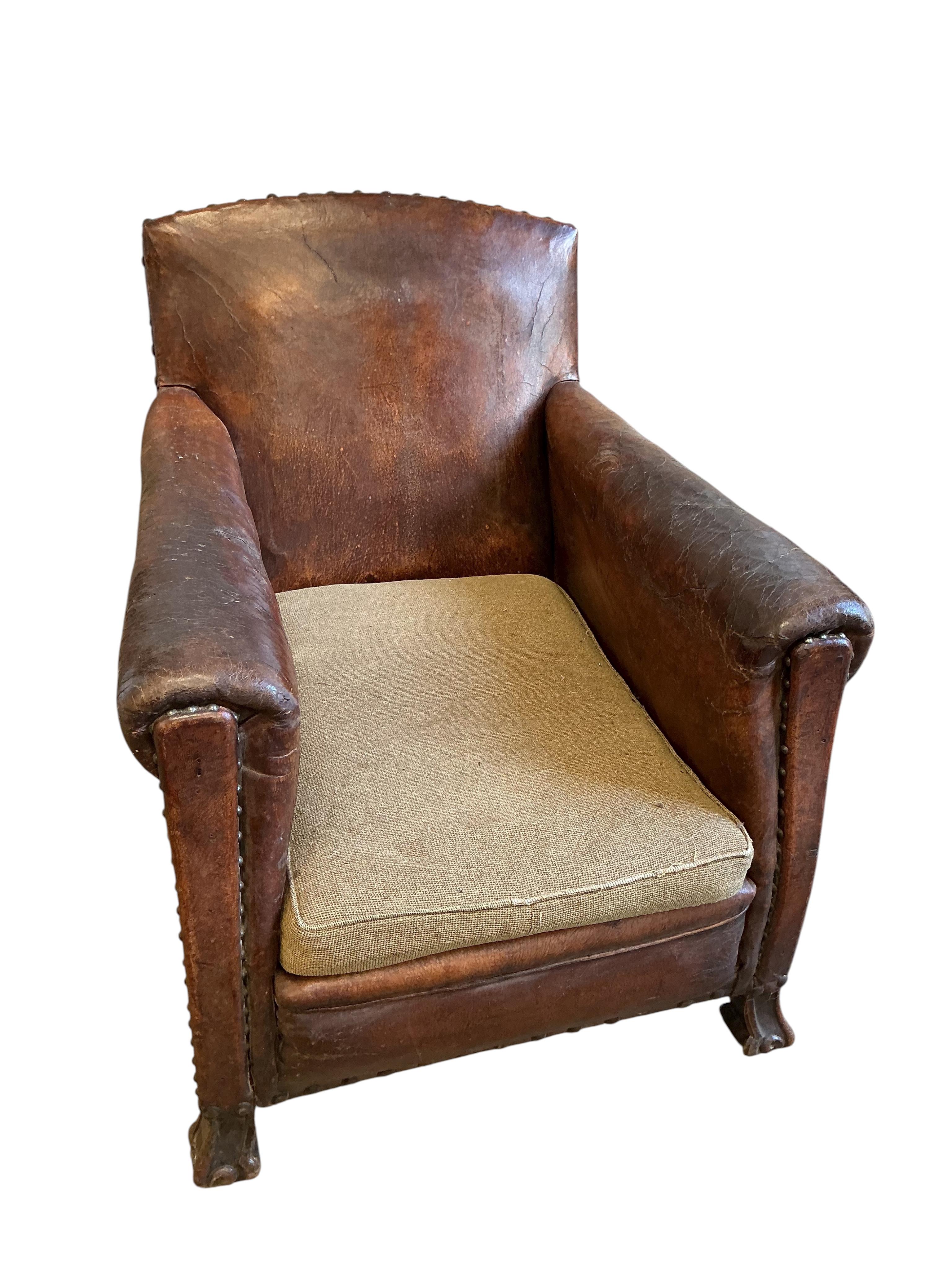 A near pair of early 20th century studded brown leather club chairs, width 79cm, depth 86cm, height 89cm